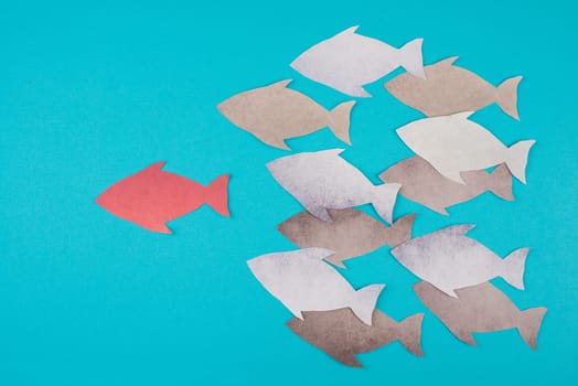 Red fish is the leader of the group, paper cut, blue colored background