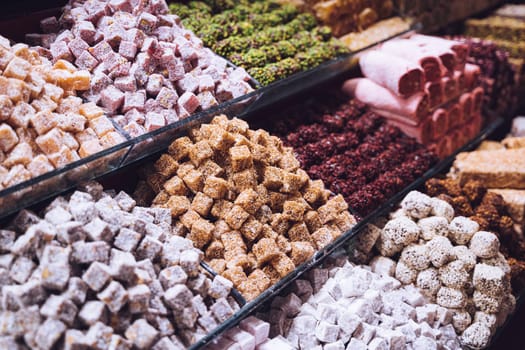 rows of Turkish delight sweets desserts with dried fruits lined up in the store window