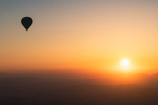 landscape with hot air balloons black silhouette rising up to the sky at sunrise with beautiful high mountain panorama in the background
