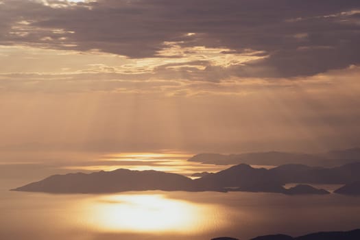 vertical aerial panorama from the Babadag peak of high mountains rising up over the Mediterranean sea at sunset near Oludeniz Blue Lagoon coast in Turkey during summer