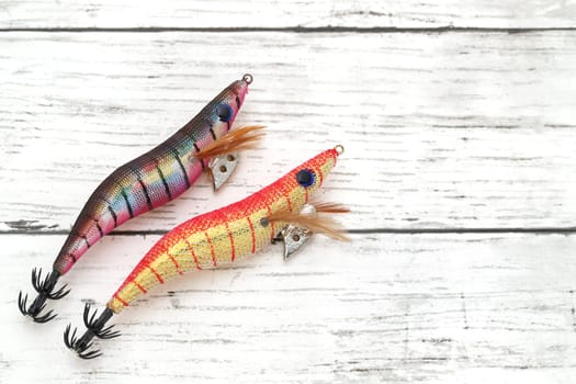 Fake bait made of shrimp shape for fishing on white wooden table