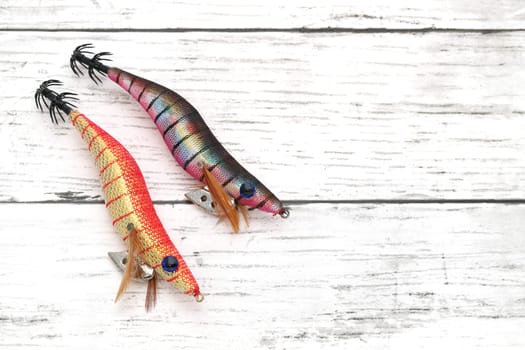 Fake bait made of shrimp shape for fishing on white wooden table