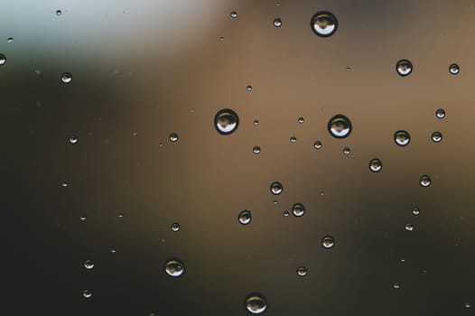 Raindrops on window glass close up. water drops macro background