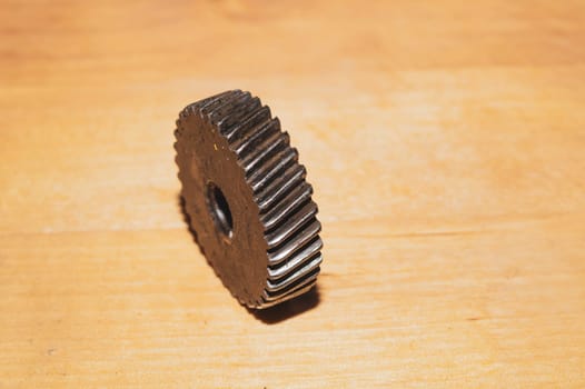 Metal gear on a wooden background. detail of mechanism