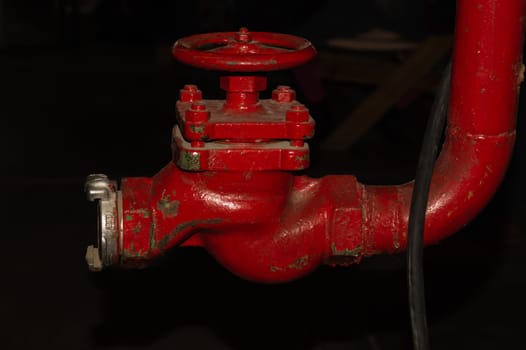 Red valve installed at fire hydrant pipe. old industrial faucet