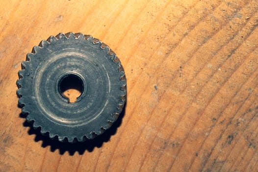 Metal gear on a wooden background. detail of mechanism