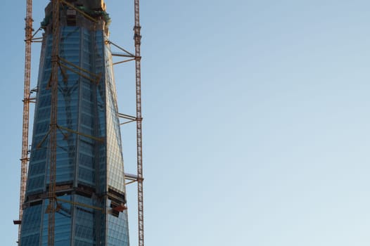 skyscraper construction. high tower with industrial crane. office glass building