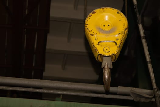 Yellow crane hook hanging in the factory. industrial background