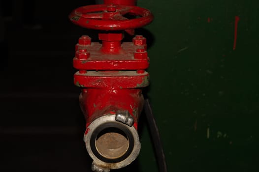 Red valve installed at fire hydrant pipe. old industrial faucet