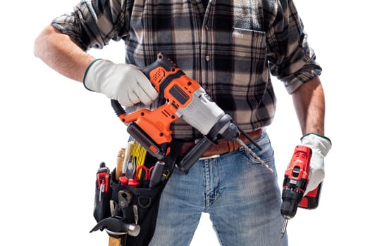 Carpenter worker at work holding the rechargeable hammer drill and the rechargeable screwdriver, isolated on white background. Construction industry. Carpentry.