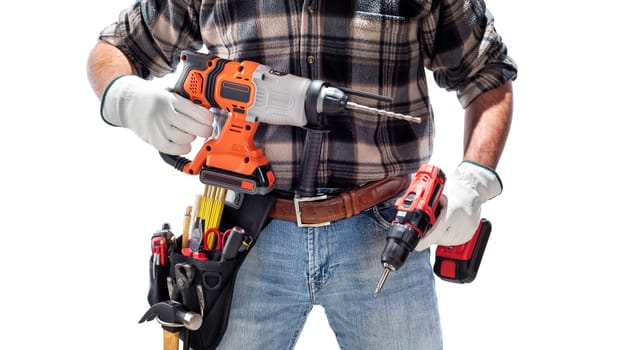 Carpenter worker at work holding the rechargeable hammer drill and the rechargeable screwdriver, isolated on white background. Construction industry. Carpentry.