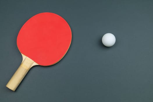 Red table tennis racket with a ball isolated on a colored background. sport equipment for ping pong. copy space