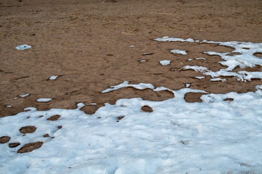 Snow covered sand. melting snow on the ground