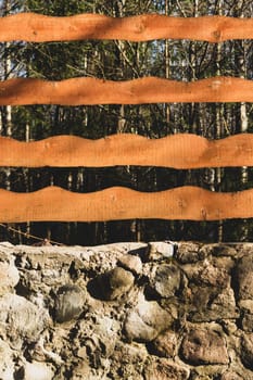 Wood and stone background. wooden fencing and natural stone wall in the park