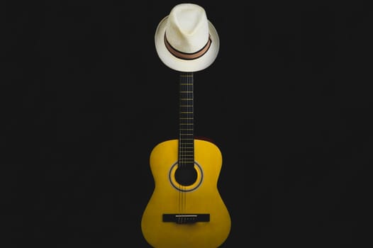 Guitar and hat in the dark. acoustic musical instrument. strings on the guitar neck close up