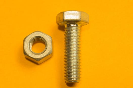 Steel screw on a yellow background. working tools