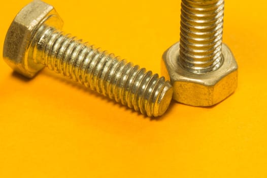 Steel screw on a yellow background. working tools