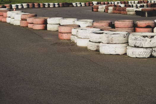 Race track safety barrier. asphalt racing track with red and white tires. colorful tires stack. karting race track