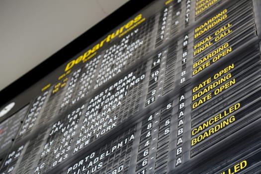 Airport departure board in terminal with flight information