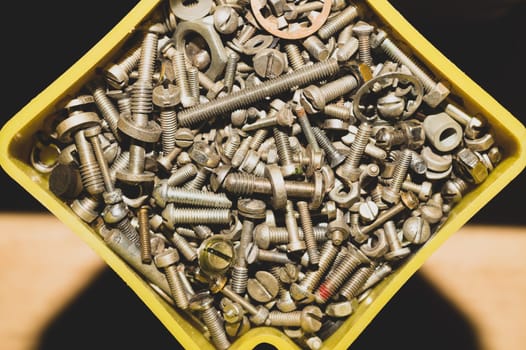 Old screws in a box. a lot of various screws. pile of fasteners in the box close up. carpentry workshop. work tool