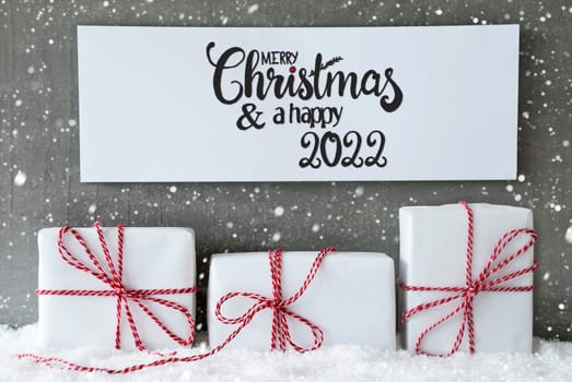 Sign With Englsih Calligraphy Merry Christmas And A Happy 2022. Three White Gifts With Red Ribbon On Snow And Cement Background, Snowflakes