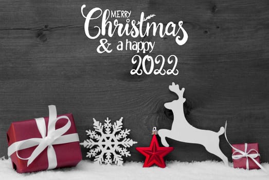 English Calligraphy Merry Christmas And Happy 2022. Red Christmas Ornament Like Present, Snowflake, Ball And Deer. Gray Wooden Background With Snow