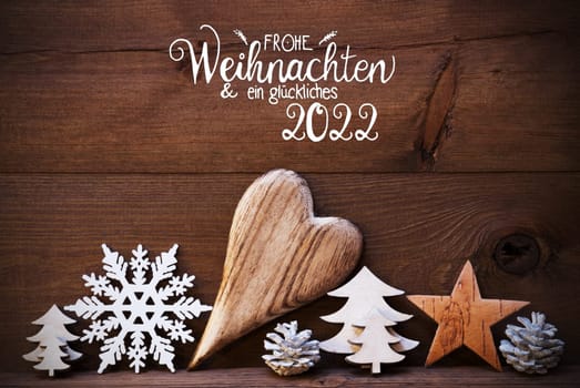 German Calligraphy Frohe Weihnachten Und Ein Glueckliches 2022 Means Merry Christmas And Happy 2022. Wooden Christmas Decoration Like Tree, Heart, Fir Cone. Brown Wooden Background