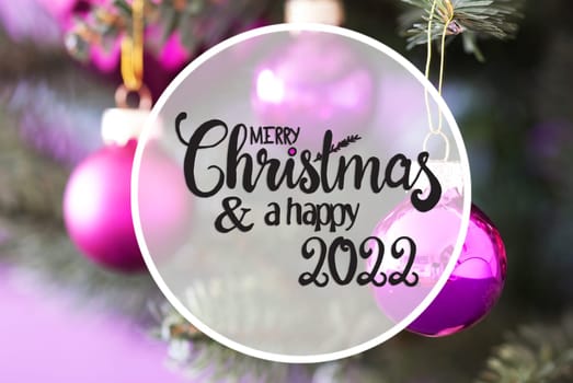 English Calligraphy Merry Christmas And Happy 2022. Blurry Christmas Tree With Pink Christmas Ornament Ball And Snowflakes