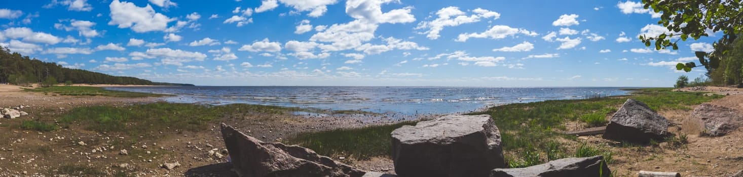 Coastline panorama. seascape with horizon line. sky with clouds. boulders on the shore