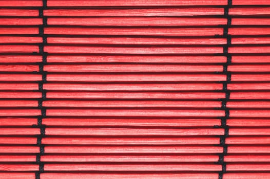 Bamboo mat background close up. wooden backdrop. red wooden sticks bound together