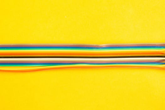 Colorful wires isolated on yellow background. connection wire for electrical schemes and devices. copy space