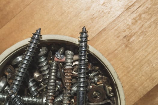 Old screws in a box. a lot of various screws. pile of fasteners in the box close up. carpentry workshop. work tool