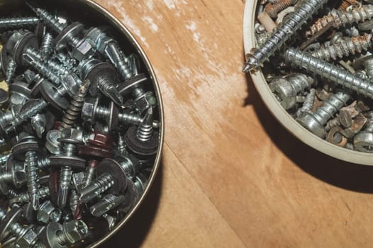 Old screws in a box. a lot of various screws. pile of fasteners in the box close up. carpentry workshop. work tool