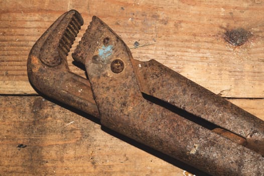 Pipe wrench on wood background. adjustable gas wrench. instrument for repair. working tool