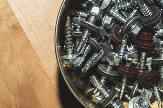 Old screws in a box. a lot of various screws. pile of fasteners in the box close up. carpentry workshop. work tool