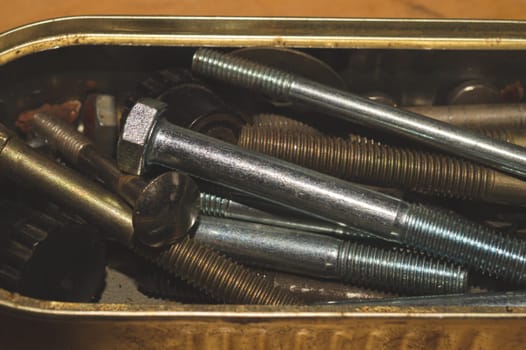 Old screws in a box. a lot of various screws. pile of fasteners in the box close up. carpentry workshop. work tool