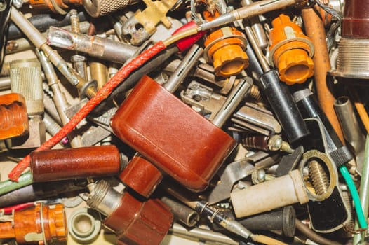 Pile of fasteners and screws close up. scrap metal. different metal parts. classic power plug. industrial background
