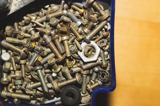 Old screws in a box. a lot of various screws. pile of fasteners in the box close up. carpentry workshop. work tool