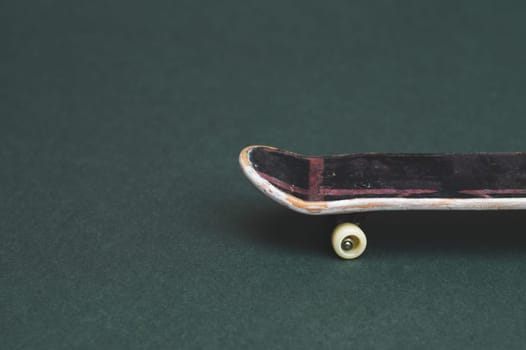 Small skateboard on color background. tiny skate for fingers. fingerboard close up. copy space