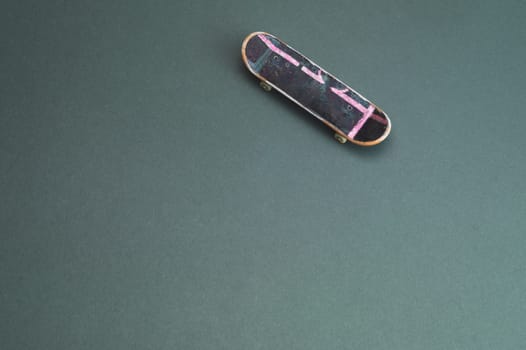 Small skateboard on color background. tiny skate for fingers. fingerboard close up. copy space