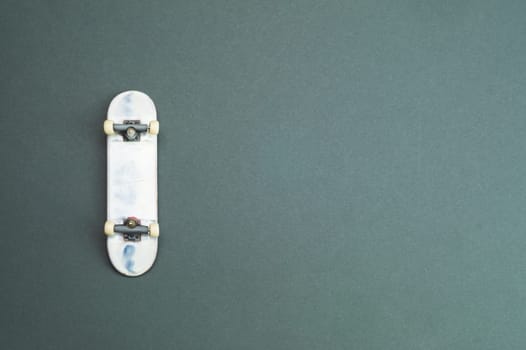 Small skateboard on color background. tiny skate for fingers. fingerboard close up. copy space