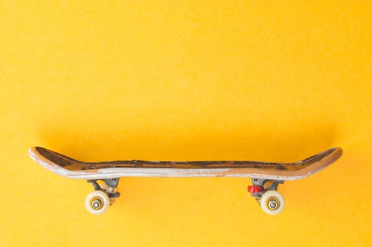Small skateboard on yellow background. tiny skate for fingers. fingerboard close up. copy space
