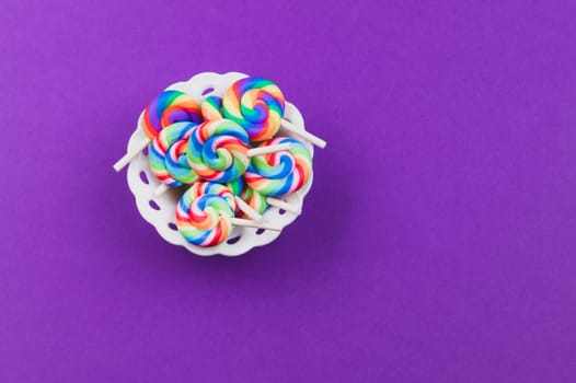 Lollipops close up. colorful candies on a purple background. festive decoration. copy space