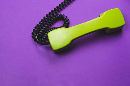 Vintage telephone handset. phone receiver isolated on purple background. old communication technology. copy space