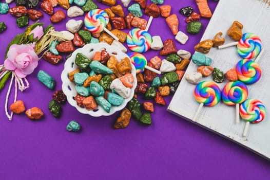 Festive decoration. lollipops and candy pebbles. sweets in the form of colored stones. colored background with colorful candies. copy space