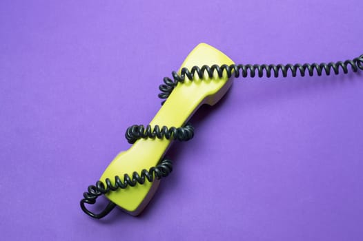 Vintage telephone handset. phone receiver isolated on purple background. old communication technology. copy space