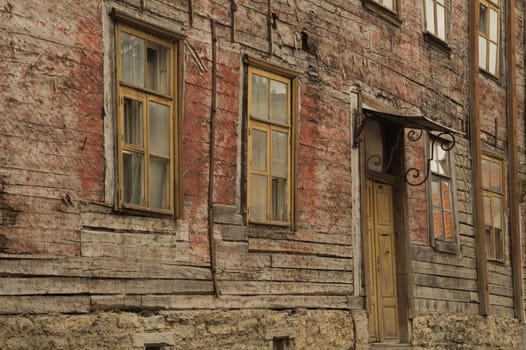 Windows of the old wooden house. wooden plank wall with windows and door background