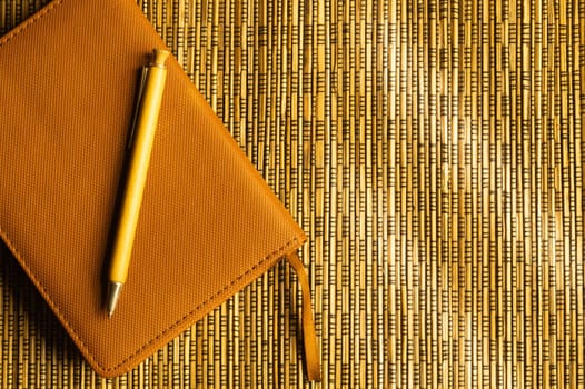 Diary and pen on a wooden bamboo background. notebook and pen top view. copy space