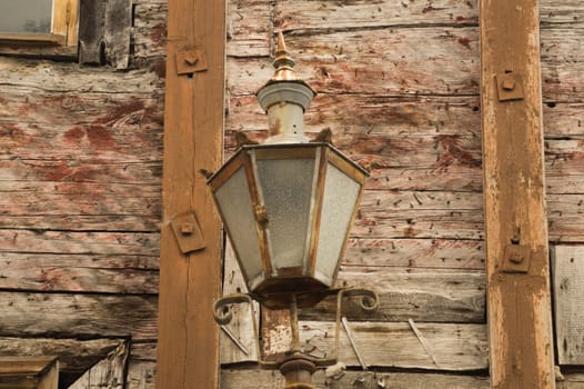 Windows of the old wooden house. wooden plank wall with vintage lamp