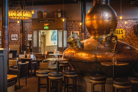 Bushmills, Northern Ireland, Aug 2019 Large, copper fermentation vat in Bushmills whiskey bar as decoration, distillery visitor centre and shop
